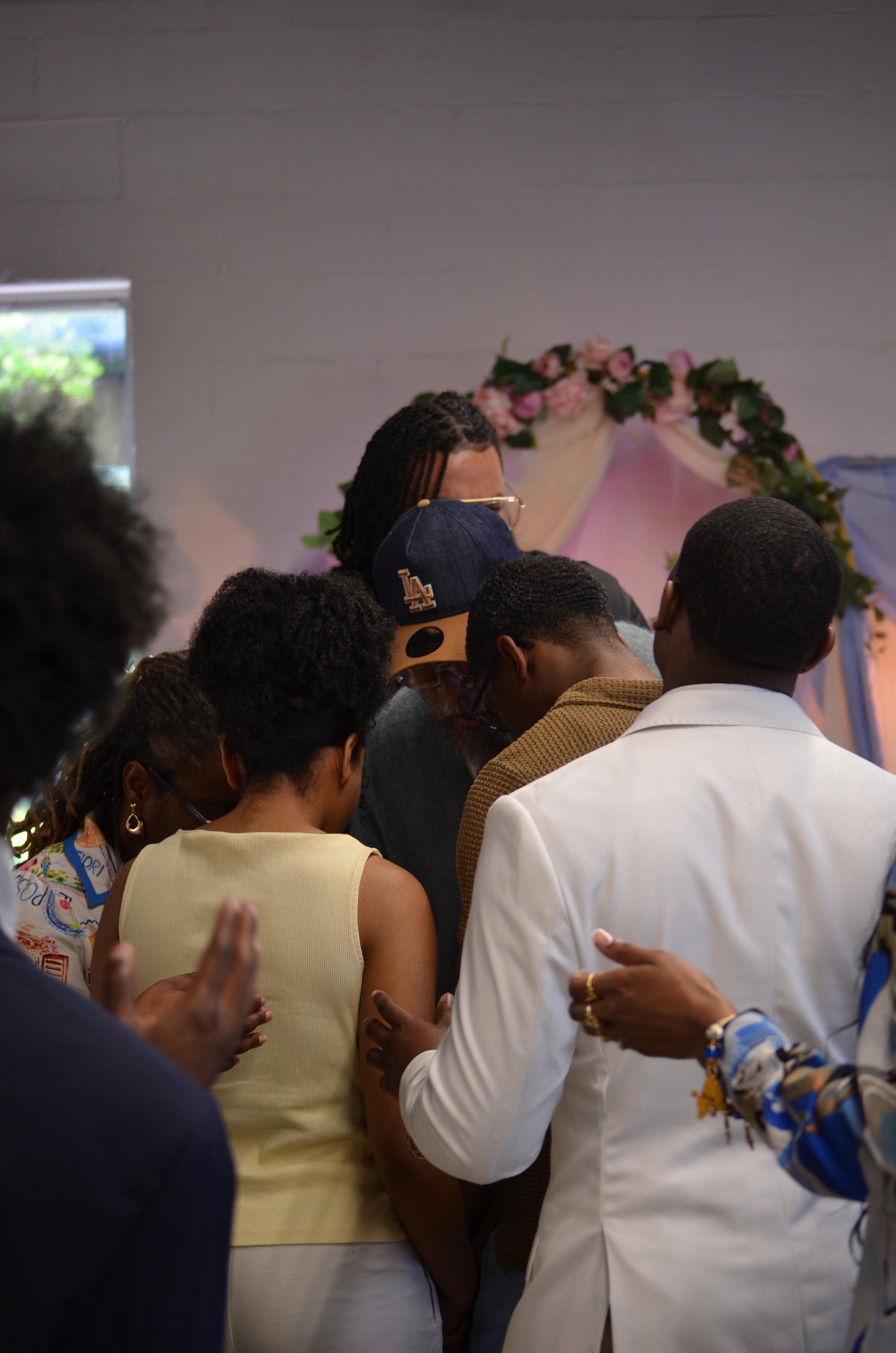 A prayer huddle with arms around one another