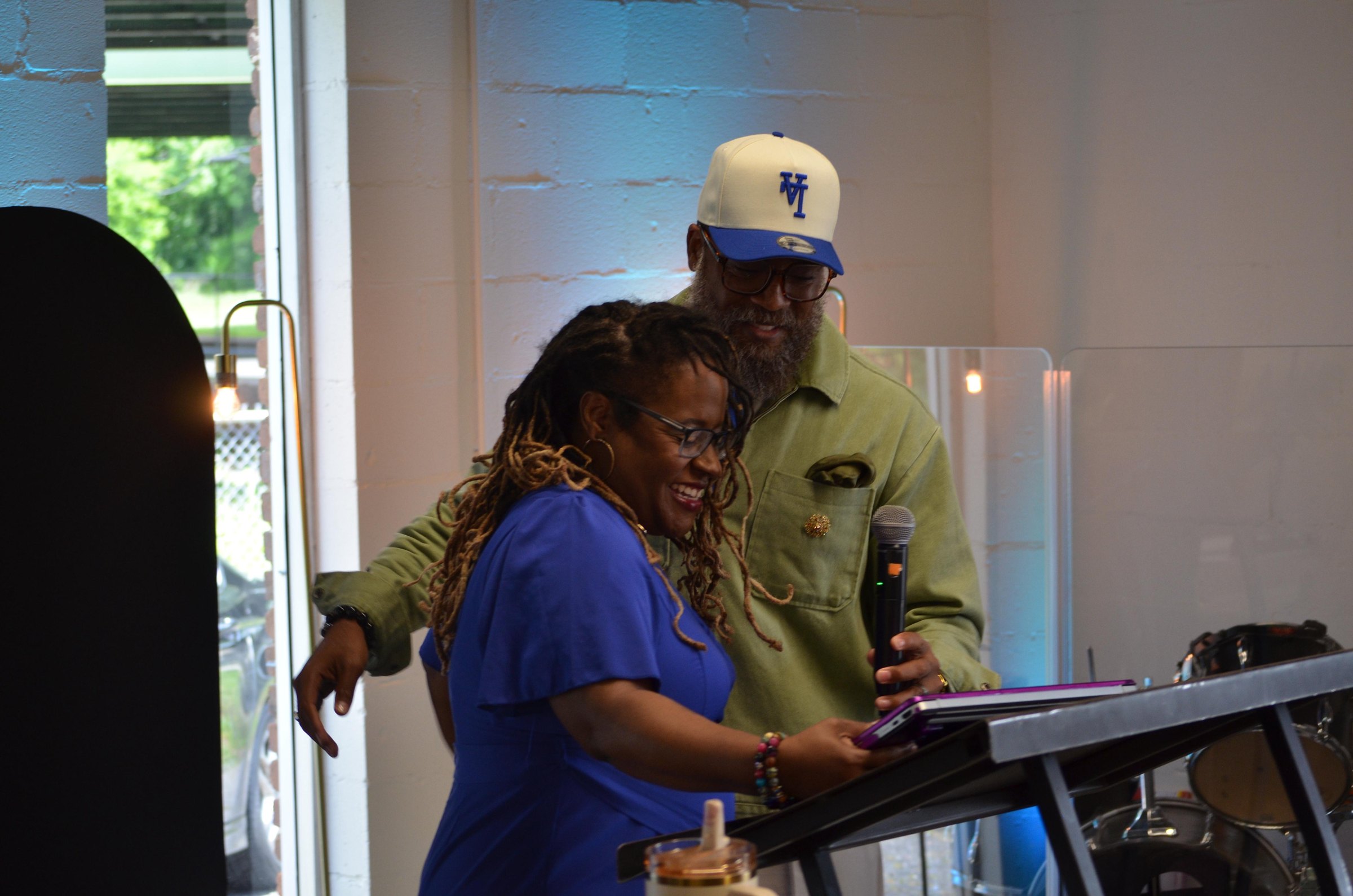 Pastor Reginald and Pastor Tamara Robinson laughing together at the front of the church
