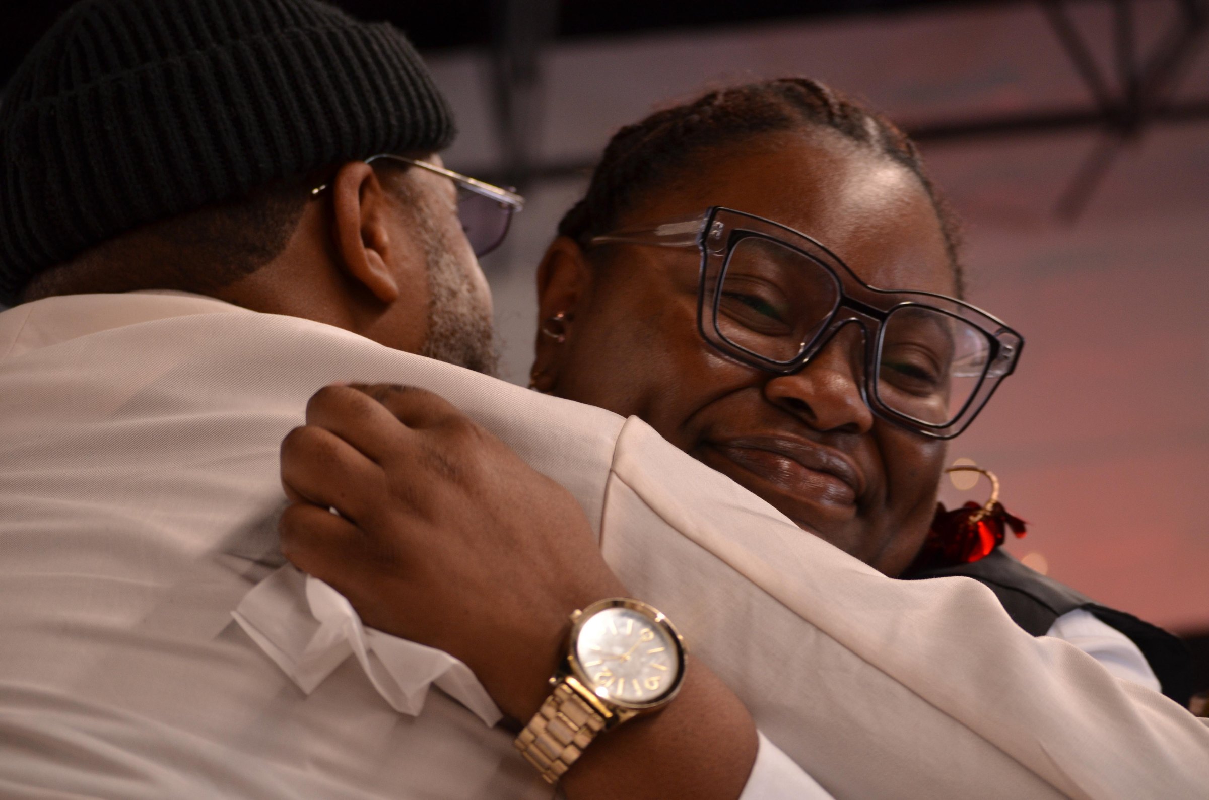 Two members holding each other close, laughing